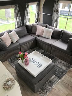 a living area with couches, coffee table and windows in the back ground is an rv