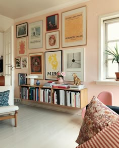 a living room filled with furniture and lots of pictures on the wall above it's bookshelf