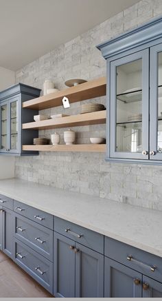 an image of a kitchen setting with blue cabinets and marble counter tops on the phone