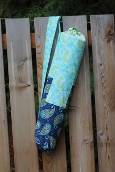 an umbrella bag hanging on the side of a wooden fence