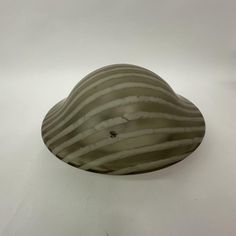 a striped glass bowl sitting on top of a white table