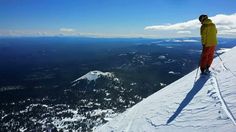 a man standing on top of a snow covered slope