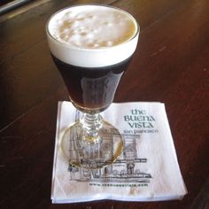 a glass filled with liquid sitting on top of a napkin