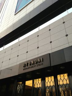 the front entrance to a building with glass doors and windows on each side that says hyddali