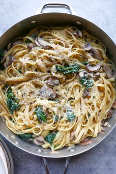 pasta with mushrooms, spinach and parmesan cheese in a pan