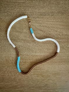 Light blue, brown, and white choker length necklace made of hand-woven glass seed beads with adjustable length closure in gold. Blue Handwoven Necklaces With Round Beads, Handmade Brown Heishi Bead Necklace, Adjustable Handwoven Blue Necklace, Adjustable Handwoven White Beads, Adjustable White Handwoven Beaded Necklaces, Handwoven Necklace, White Choker, Length Necklace, Glass Seed Beads