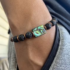 The copper healing bracelet is an authentic piece of Native American jewelry, featuring abalone shell and black lava beads in a modern bohemian style. This men's beaded bracelet makes a meaningful gift for him, combining cultural significance with healing properties. 🪶 𝗠𝗔𝗧𝗘𝗥𝗜𝗔𝗟𝗦 + 𝗗𝗜𝗠𝗘𝗡𝗦𝗜𝗢𝗡𝗦 ❯  Abalone Shell, 8mm Stone Beads, Copper ❯  Heavy Duty Elastic Cording 🪶 𝗦�𝗧𝗢𝗡𝗘 + 𝗘𝗟𝗘𝗠𝗘𝗡𝗧 𝗘𝗡𝗘𝗥𝗚𝗬 ❯  COPPER enhances positive energy flow ❯  ABALONE is known for its pow Abalone Shell Bracelet, Cotton Travel Bag, Bracelets Hippie, Abalone Bracelet, Black Beaded Bracelet, Boho Men, Black Beaded Bracelets, Hippie Bracelets, Bracelet Mens