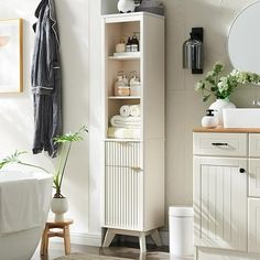 a bathroom with a white cabinet, sink and mirror in it's corner next to a bathtub