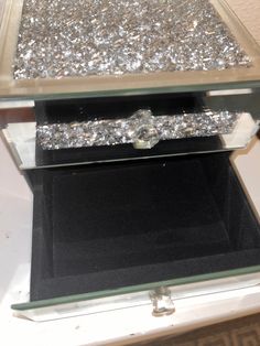 a glass box with some silver glitter on it