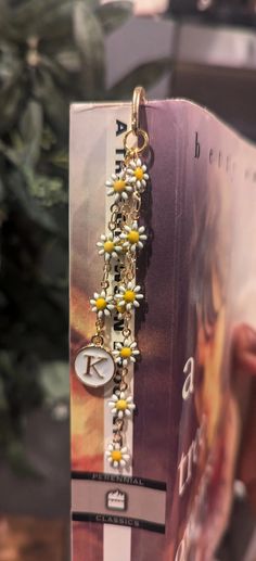 a book with some yellow and white flowers attached to it's front cover, sitting on a table