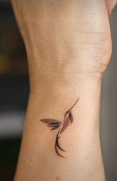 a small hummingbird tattoo on the back of a woman's left arm,