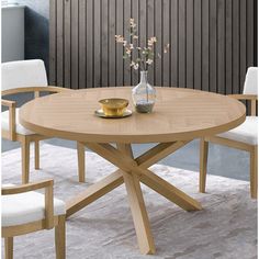 a wooden table with white chairs around it and a vase on the table next to it