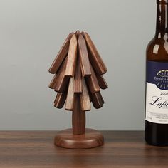 a wooden christmas tree next to a bottle of wine