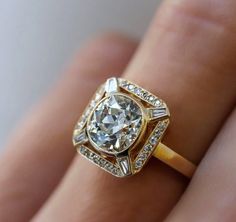 a woman's hand with a yellow gold ring and diamond set engagement ring on it