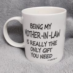 a white coffee mug with black writing on it that says, being my mother - in - law is really the only gift you need