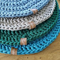 three crocheted hats are stacked on top of each other, one blue and the other green