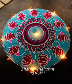 a lit candle is placed in the center of a decorated rangdi with red and pink flowers