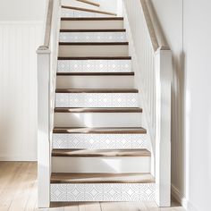 the stairs are painted with white and beige geometric designs on them, along with wood flooring