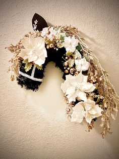 a wreath is hanging on the wall with flowers