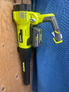 a cordless screwdriver attached to the side of a blue bed with wood planks