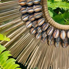 Inpired by traditional tribal necklace. This nice piece of decoration is made of shells sewn on macrame coton fiber boarded with natural dried grass . Symbolizing wealth, this necklace is the perfect decorative master piece for your interior. Supplied with its black metal and wood presentation stand. Each piece is unique! More than just a decorative object, this Papua necklace immerses you in the heart of Papuan traditions where history, culture and tradition blend together. Dimensions : 40 x 32 Traditional Handmade Shell Necklace For Festival, Handmade Bohemian Brown Shell, Handmade Brown Bohemian Shell, Traditional Shell Necklace For Beach, Bohemian Brown Shell, Bohemian Natural Shell Necklace For Festival, Wood Presentation, Cowrie Shell Necklace, Snake Head