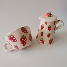 two ceramic cups with strawberries painted on them