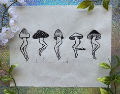 four different types of mushrooms on a piece of paper next to flowers and glitters