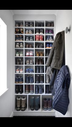 a coat and shoes are hanging on the wall next to a shoe rack with many pairs of shoes