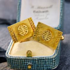 These bold cufflinks have a rectangular face with a symbol reminiscent of the Chinese character for "long life." The face has a Florentine finish with a Greek key pattern on each end of the rectangle. They are crafted in 14k yellow gold with a stunning patina and are finished with a toggle closure. Rectangular Gold Ceremonial Jewelry, Ceremonial Gold Rectangular Jewelry, Rectangular Gold Jewelry For Ceremonial Occasions, Luxury Rectangular Cufflinks With Polished Finish, Luxury Rectangular Cufflinks For Anniversary, Luxury Rectangular Cufflinks For Wedding, Luxury Rectangular Jewelry For Ceremonial Occasions, Rectangular Engraved Cufflinks For Formal Occasions, Gold Rectangular Cufflinks For Anniversary