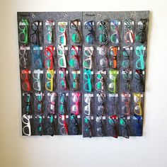 several pairs of glasses are hanging on the wall