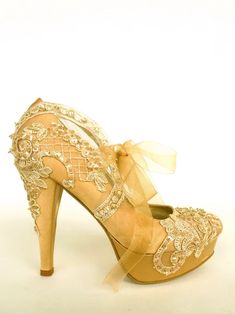 a pair of high heeled shoes with gold lace and bows