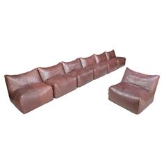 a brown leather sectional sofa and ottoman with matching footstools on an isolated white background