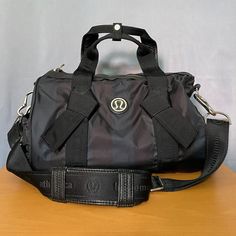 Size: 13lx6wx9h (App Measurements) Brand: Lululemon Athletica Color: Black W/ Off Black/Navy Stripes; Silver Hardware Condition: Good Pre-Owned Only Used A Few Times But Never For Gym Items; Has Wear/Markings And Paint Smudge On Bottom Of Bag; Peeling To Inside Of Handle; Missing Zipper Pull On Main Opening, Only Ring Is Attached (Flaws Shown In Pics/Video) Style: Dtb Down Time Bag; Mini Cross Body Nylon Shoulder Bag; Removable Shoulder Strap; Side Exterior Pockets Includes "Phone"Slot; Interior Pockets Includes "Sweaty Wet Unmentionables" And "Tunes" Slots; Rare/Discontinued/Hard To Find/No Longer Made Please Reach Out W/ Any Questions! Gym Bag, Yoga, Lululemon Athletics, Lulu Paint Smudge, Gym Items, Video Style, Nylon Shoulder Bag, Mini Cross, Off Black, Navy Stripes, Duffel Bag, Silver Hardware