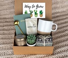 an open box with coffee, tea and other items in it sitting on a blanket