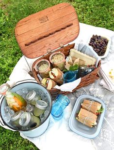 a picnic with food and drinks on the grass