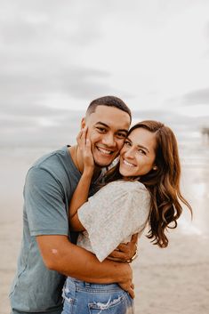 a man and woman hugging on the beach