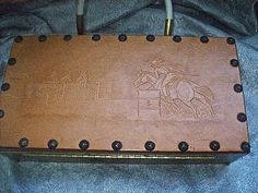 a wooden box with a drawing of a horse and rider on it's side