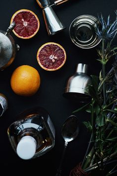 grapefruit, oranges, and other ingredients on a table with silverware