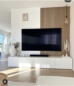 a large flat screen tv mounted to the side of a wall in a living room