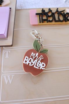 an apple shaped keychain sitting on top of a table