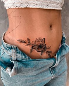 a woman's stomach with a flower tattoo on her belly and the bottom part of her stomach