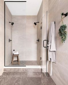 a walk in shower sitting next to a wooden bench