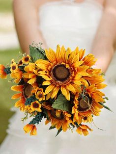 a bride holding a bouquet of sunflowers