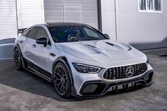 the mercedes amg gt is parked in front of a garage