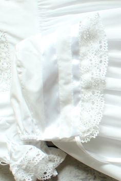 Designed to coordinate with our heirloom christening gowns, this vintage-inspired bonnet in 100% cotton is finished with crocheted lace and satin ribbon ties. Many of you requested a larger bonnet option, so we added a size 12 month bonnet, sold separately, to be worn with our Savannah dress, Virginia dress, or Margaret dress. Bonnet is available in white or ivory. Fitted White Bonnet With Lace Trim, Fitted Cotton Baptism Dress With Lace Trim, Elegant Lace Bonnet With Lace Trim, Fitted Cotton Bonnet With Lace Trim, White Fitted Bonnet For Baptism, Fitted White Bonnet For Baptism, Wedding Bonnet With Lace Trim, Fitted Cream Bonnet With Lace Trim, White Cotton Bonnet For Baptism