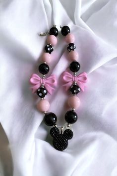 a pink and black necklace with a minnie mouse charm