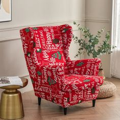 a red chair sitting on top of a hard wood floor next to a potted plant