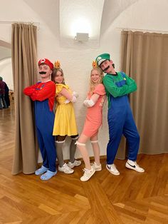 three people dressed in costumes posing for a photo with mario and luigi on their faces