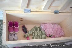 a wooden box filled with pink and green items on top of a carpeted floor