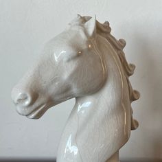 a white ceramic horse head sitting on top of a table